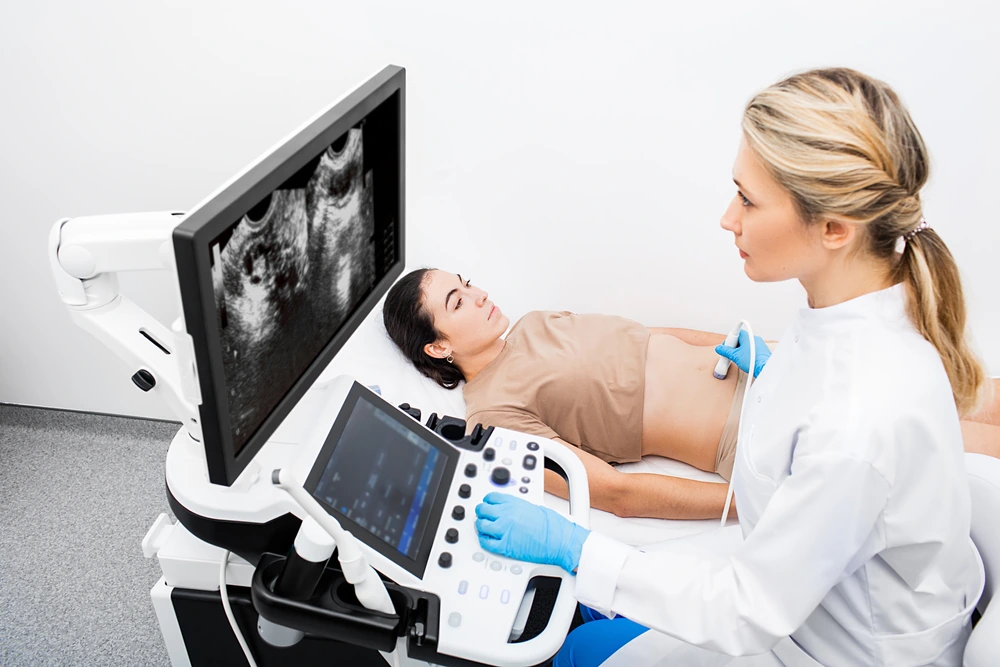 Woman having an ultrasound examination of uterus and ovaries at the gynecologist office in a modern clinic